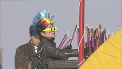 A woman wearing novelty glasses and a fake Mohawk places fireworks onto a stand for lighting. Stock Footage