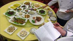 Chefs with notebooks judge food displays on a lazy Susan at the Panda Display Center in China. Stock Footage