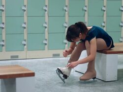 A female figure skater lacing up skates Stock Footage