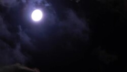 Spooky moon between passing clouds Stock Footage
