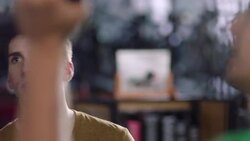 Customer hands bicycle wheel to mechanic in bike repair shop Stock Footage