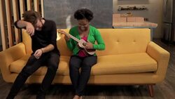 Friends jumps on sofa and play ukelele Stock Footage