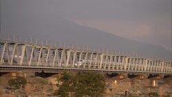 A bullet train travels over a bridge on a cloudy day. Stock Footage