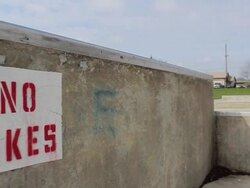 A young man rides his BMX bicycle and does a trick despite a sign that says 'No Bikes'. - Model Released - HD Stock Footage