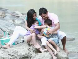 Family playing with a ball at riverbank  Stock Footage