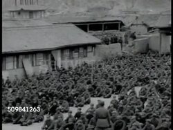 1944: NORTHERN CHINA: EXT Communist Red Army headquarters. Communist Red Army soldiers gathered in courtyard, standing, then quickly sitting on command. VS Seated soldiers. Officer speaking to troops (no SOT). Communist Red Army soldiers walking. Instructional Video