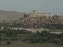 Buildings and dwellings are stacked on a Moroccan hillside, surrounded by African, agricultural land. Stock Footage