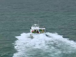 MS AERIAL ZO Shot of people cleaning in motorboat on sea with landscape / Languedoc Roussillon, France Stock Footage