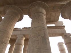 Medium, pan-left tracking-right - Hieroglyphics cover columns and ceiling supports at the ruins of an ancient Egyptian building Stock Footage