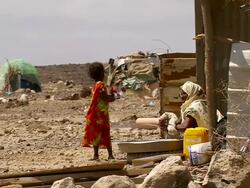 WS View of woman washing laundry in refugee camp with little girl / Refugee camp Djibouti, Djibouti Stock Footage