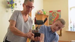 Mother showing funny videos to disabled son Stock Footage