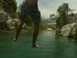 High Speed Man splashes in to waterfall pool, from behind, Spain. (Individual frames may also be used as a still image. Each frame in its raw state is about 6MB or about 12MB as a 16 bit TIFF) Stock Footage
