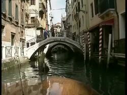 POV from motorboat, Travelling down narrow canal as it approaches row of arched bridges, Venice Stock Footage