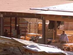 ZO and PAN across wooden pallet manufacturing and repair facility / Fontana, California, USA Stock Footage