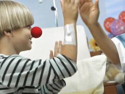 HD: Red Nose Nurse Entertaining A Child Stock Footage