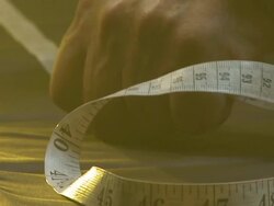 CU TU Shot of man measuring fabric out with tape measure / South Africa Stock Footage