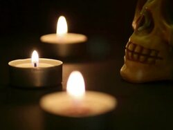 spooky skull on a bier lighted by candles Stock Footage