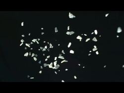 Shards of ice or glass falling against black background Stock Footage