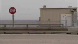 A bridge features a stop sign located next to a maintenance building. Stock Footage
