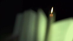 Slow Motion of Opening Book Pages Under Candle Light Stock Footage