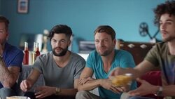 Guys sitting on couch watching tv Stock Footage