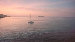 A yacht is moored in a natural harbour in the Burmese archipelago at sunrise Stock Footage