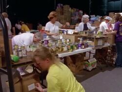 September 2005 Wide shot volunteers sorting cans and packing boxes at Hurricane Katrina relief center / Mississippi Stock Footage