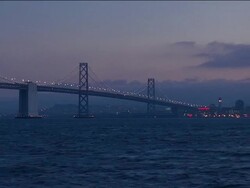 WS Bay Bridge at dusk / PAN over San Francisco Bay to skyline / San Francisco, California Stock Footage