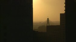 A golden sky outlines ANZAC Bridge beyond a silhouetted skyscraper in Sydney, Australia. Stock Footage