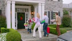 Excited grandmother welcomes family home for the holidays, hugs all around (dolly-shot) Stock Footage