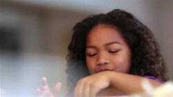 Cute young girl sprinkles flour on cookie dough and flattens it out with rolling-pin Stock Footage