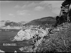 1939: CALIFORNIA PARKS: VS River & mountains. BEACHES: Cove beach w/ people in Pacific Ocean water, umbrellas on sand shore. VS People sunbathing, young brunette sitting, smoking. Children playing in surf, some w/ inflated inflatable rafts. Instructional Video
