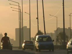 MS Man jogging along Malecon at sunrise with buildings and traffic / Havana, Havana, Cuba Stock Footage