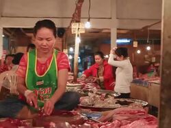 WS POV SLO MO Woman vendor sitting at stall and loaded hand cart passing by at morket / Vientiane, Laos Stock Footage