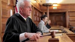 Judge banging gavel at bench in courtroom Stock Footage