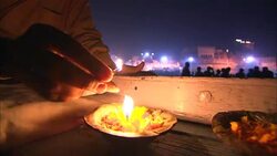 In a boat a hand lights a candle then places it in the river. Stock Footage