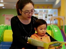 MS Shot of mother and daughter reading book in playroom / Xian, China Stock Footage