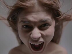 front view of young, naked woman yelling as she leans towards the camera Stock Footage