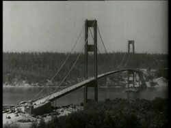 B/W 1940's high angle wide shot of Tacoma Narrows Bridge over river / SOUND Stock Footage