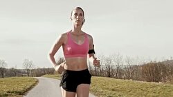SLO MO TS Female running on a road in sunshine Stock Footage