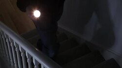Intruder with flashlight on stairs. Stock Footage