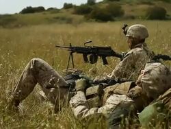 MS One soldier slepeping on grass another soldier with heavy machine gun keeping watch AUDIO / Camp Pendleton, CA, United States Stock Footage