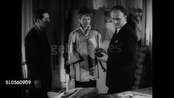 1947: FRANCE FASHION: BALMAIN: LA MS Sign 'Pierre Balmain.' INT MS Designer Balmain (1914-1982 R) designing w/ French model in shift dress top &amp; assistant. MS Drawing pencil sketch of women's top. Paris Instructional Video