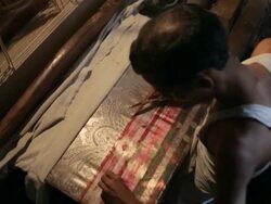 MS HA Man embroidering sari with gold thread / India Stock Footage