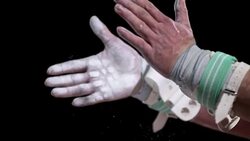 SLO MO Gymnast wearing grip clapping hands dusted with chalk Stock Footage