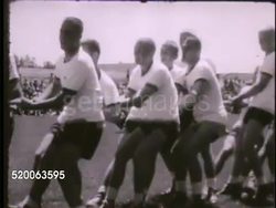 1963: UNITED STATES AIR FORCE ACADEMY: VS Groups of cadets engaging in tug of war on field, group in white shirt winning. HA WS PAN Various cadets gathered on field during competition, games. VS Cadets foot racing on field. Recreation, sports, PT Instructional Video