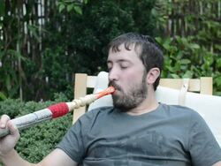 Young man blowing smoking water pipe and drinking tea Stock Footage