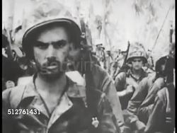 1943: BETIO, TARAWA: MS (POV in center) US Marines walking by. Unidentified soldier smiling at soldiers walking by.  World War II. WWII. Instructional Video