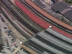 Aerial medium shot zoom out wide shot Great North Eastern Railway (GNER) train pulling into York Station / York, England Stock Footage