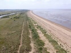 Aerial over dune grass along Heacham Beach Stock Footage